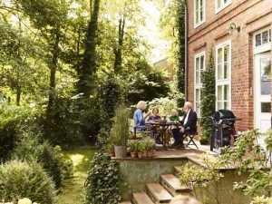 Mobiler Gas-Griller und Familie auf Terrasse