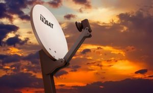 Satelliten-Schüssel auf Gebäudedach vor Nachthimmel